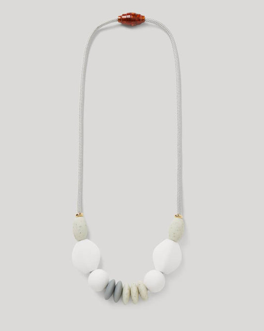 teething necklace for parents of small children. white and gray silicone beads on a cord.