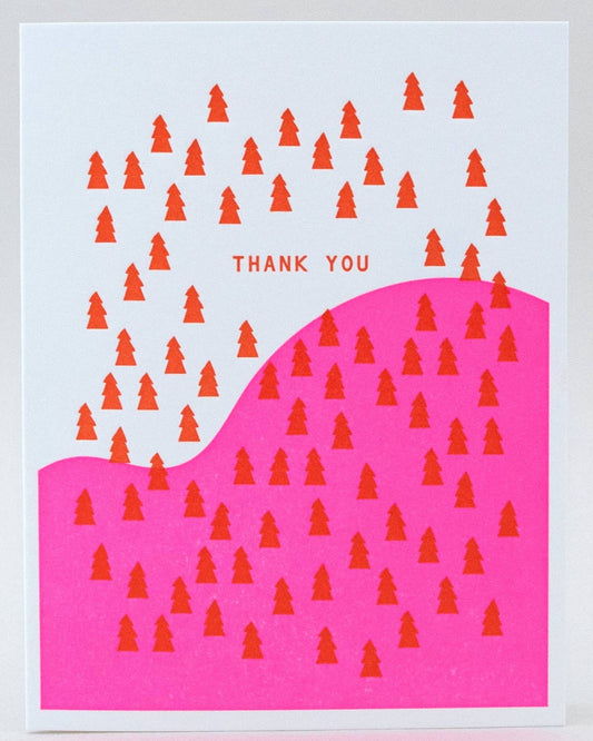 A folded greeting card with a red and orange forest pattern on a pink background, and a message that reads 'Thank You'.