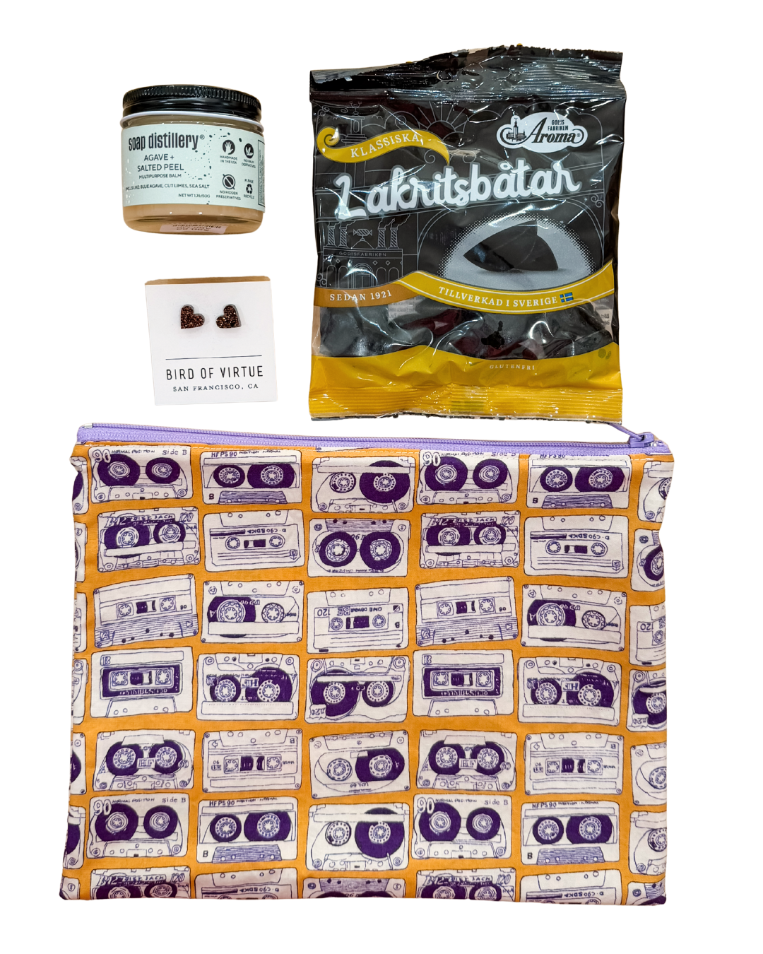 cotton zip Pouch with cassette tape pattern, jar of hand balm, black licorice, and earrings, on a white background