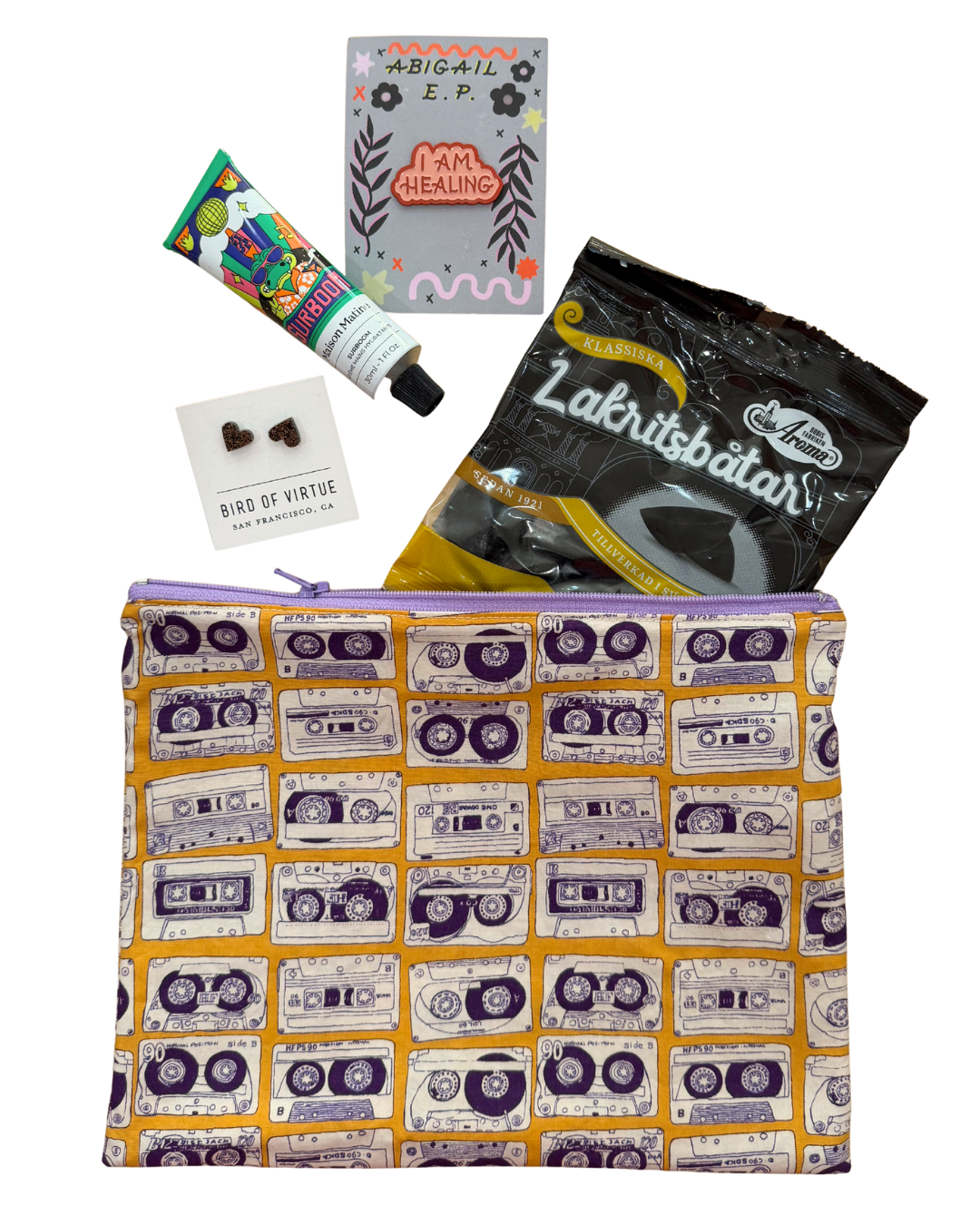 Pouch with cassette tape pattern surrounded by various items on a white background