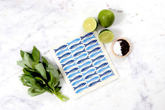 swedish dishcloth with blue sardine design on a white marble counter