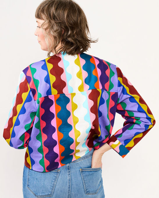 Person wearing a colorful patterned shirt on a white background