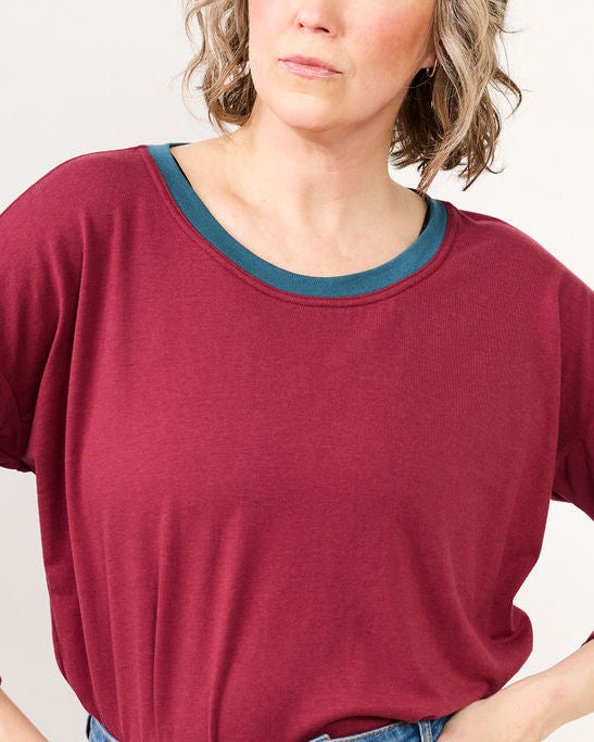 Woman wearing a burgundy sweater with a plain background
