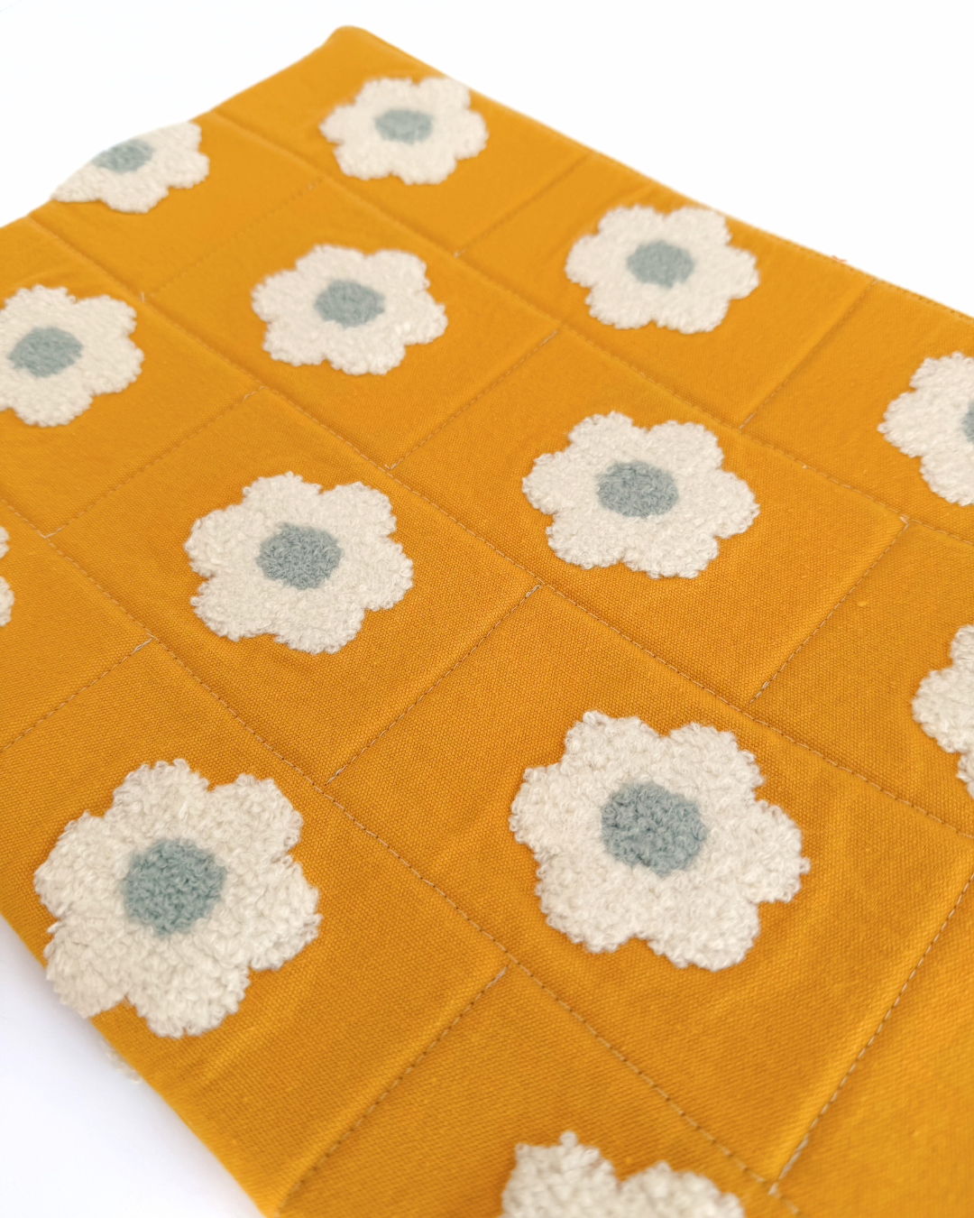 close up of Yellow laptop pouch with white floral patterns on a white background
