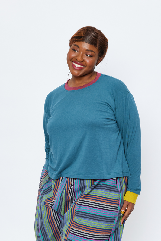 plus size woman wearing a soft blue bamboo top and smiling