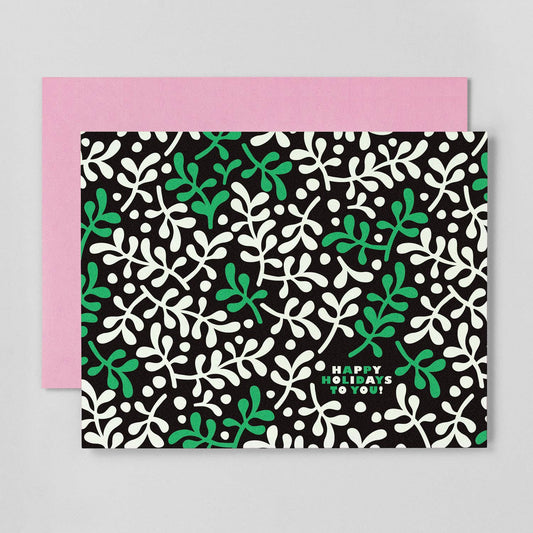 A holiday card with an abstract mistletoe pattern, predominantly green and black, with a blank inside for a personal message.