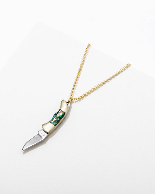 A necklace with a switchblade pendant, featuring a long gold-colored chain and a knife with a blue and white handle.