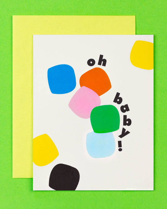A greeting card with a colorful geometric pattern and the text 'Oh Baby!' displayed prominently in the center, paired with a matching envelope.