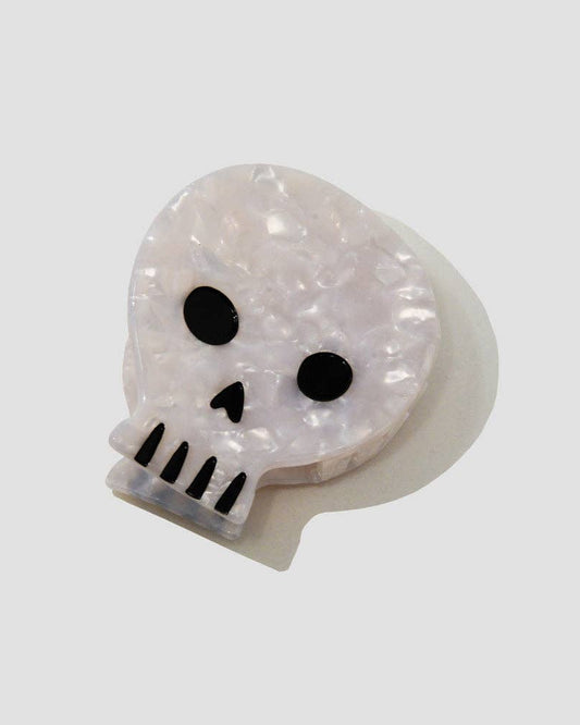 Skull-shaped hair claw with black details on a white background