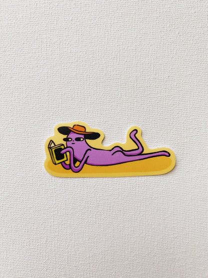 Cartoon sticker of a purple person lounging with a hat and sunglasses on a yellow background
