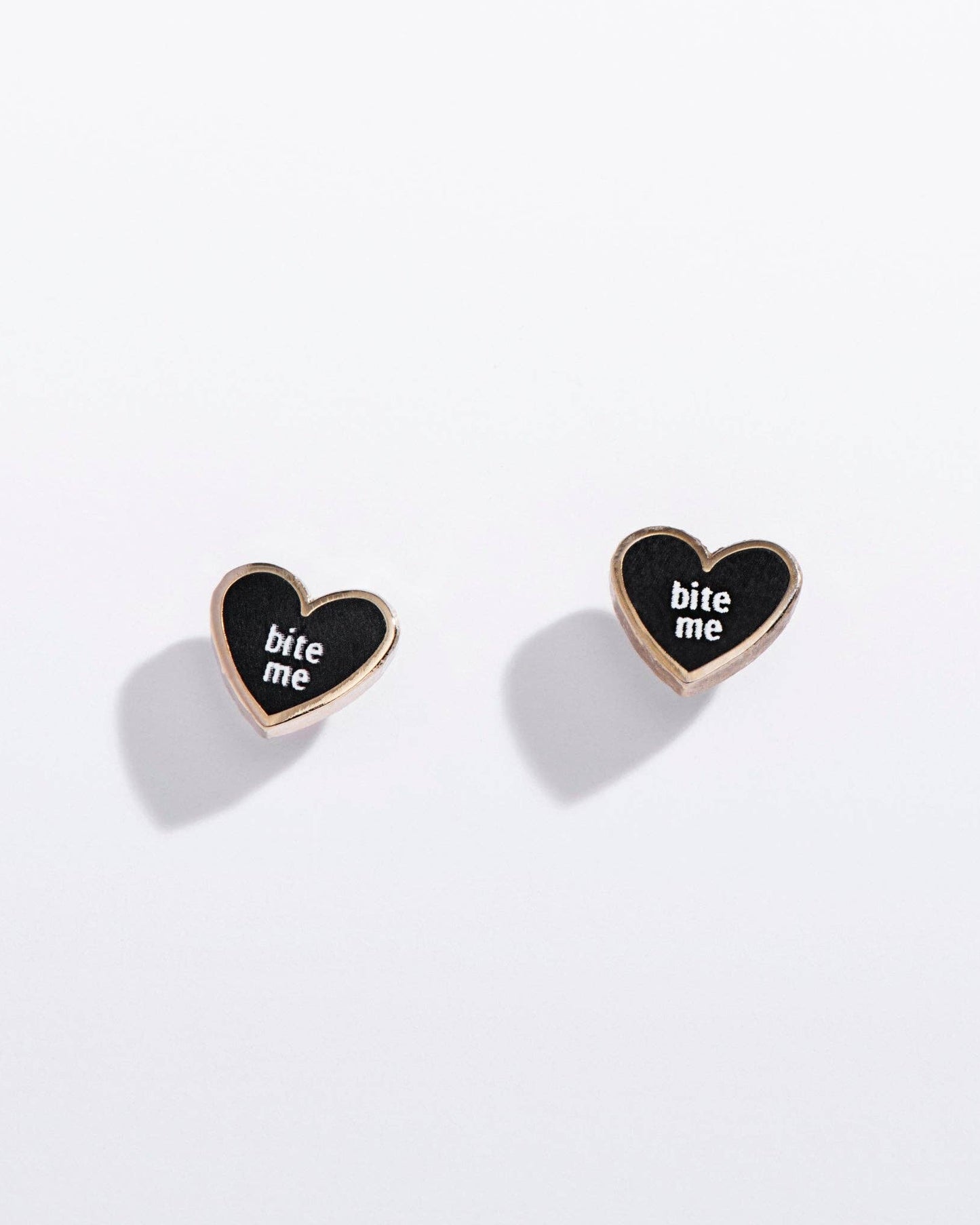 Heart-shaped earrings with 'bite me' text on a white background