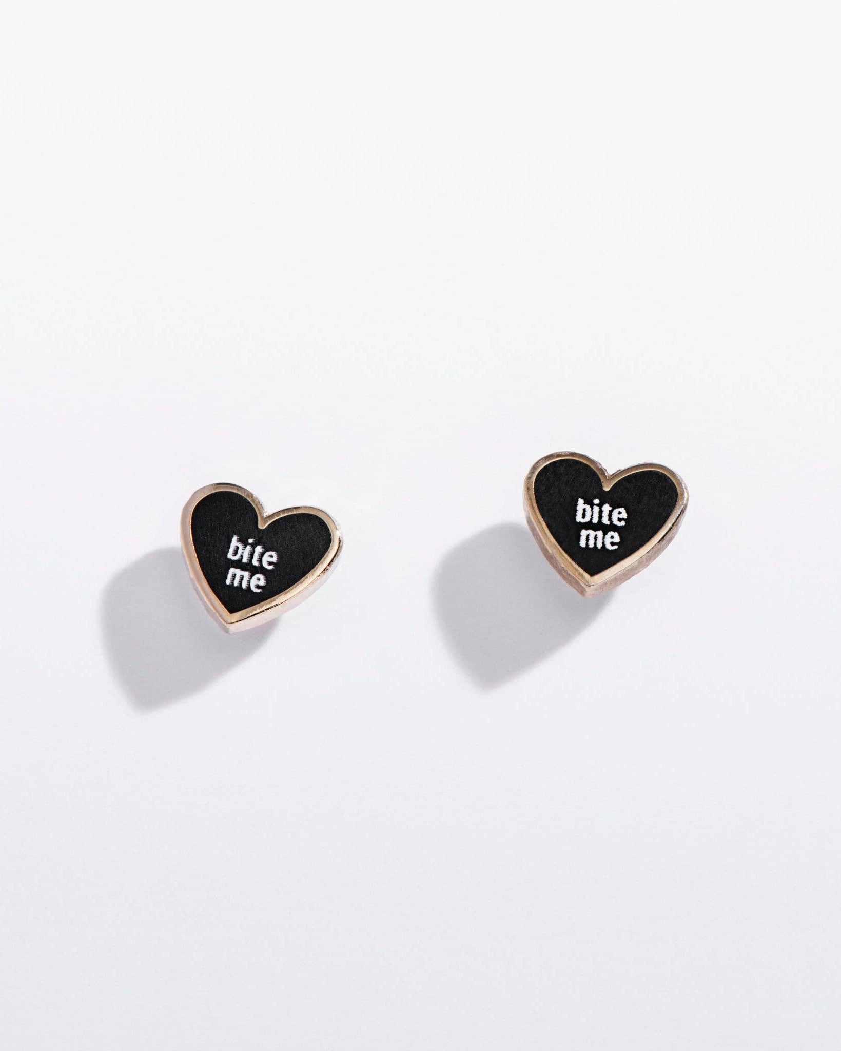 Heart-shaped earrings with 'bite me' text on a white background