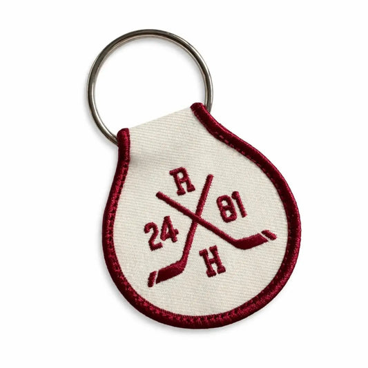 Keychain with Heated Rivalry embroidered design on a white background