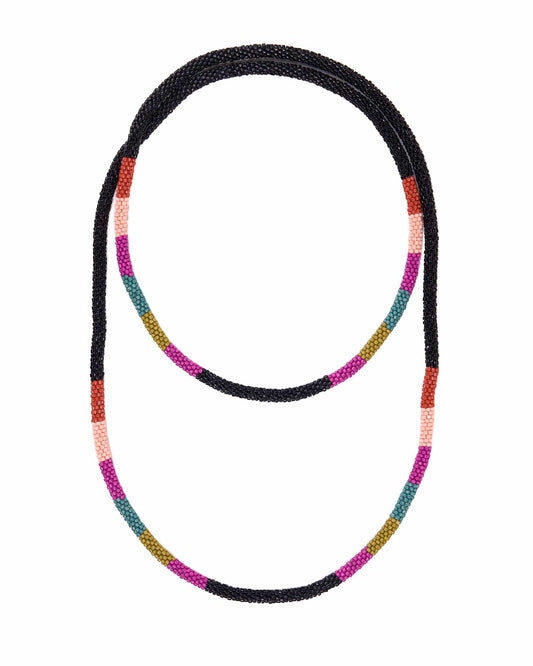 A beaded necklace with a black textured base and alternating colorful segments of pink, orange, teal, and olive green, shown on a plain white background.