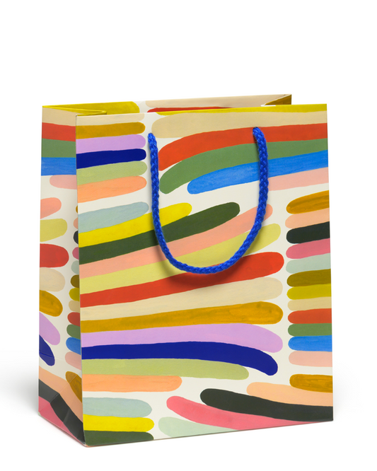 Colorful gift bag with abstract pattern and blue handle on a white background