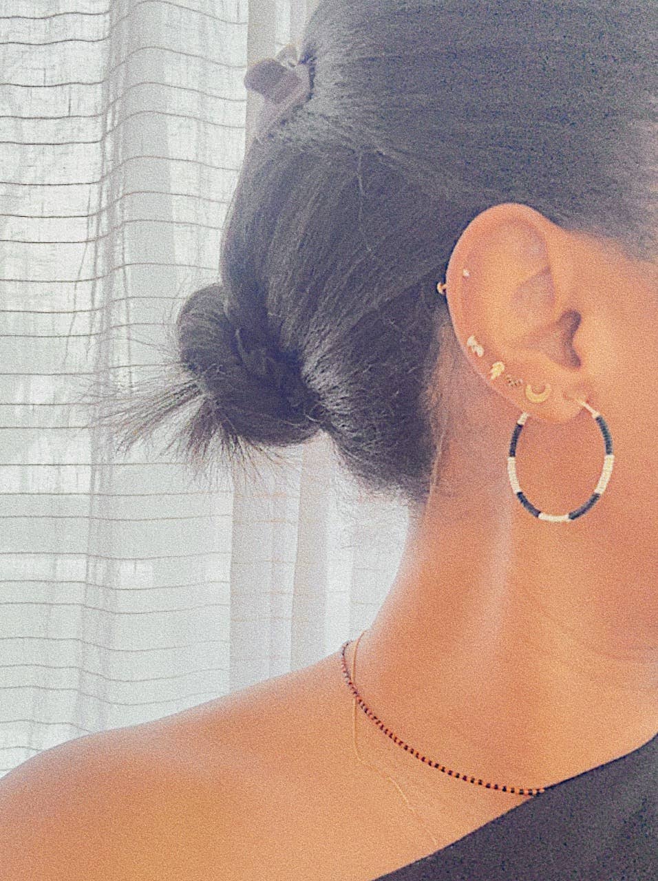 Person wearing a hoop earring with a blurred background