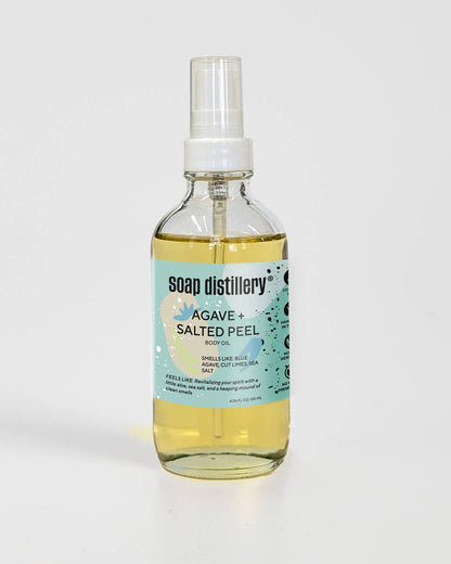Bottle of Soap Distillery Agave + Salted Peel body oil in a glass container on a white background