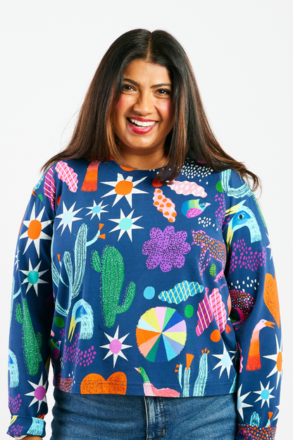Woman wearing a colorful patterned shirt with abstract shapes on a white background