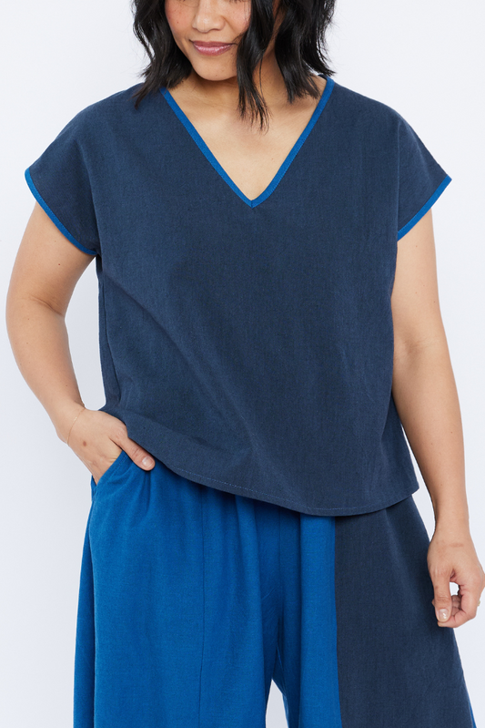 Woman wearing a blue outfit with a plain background