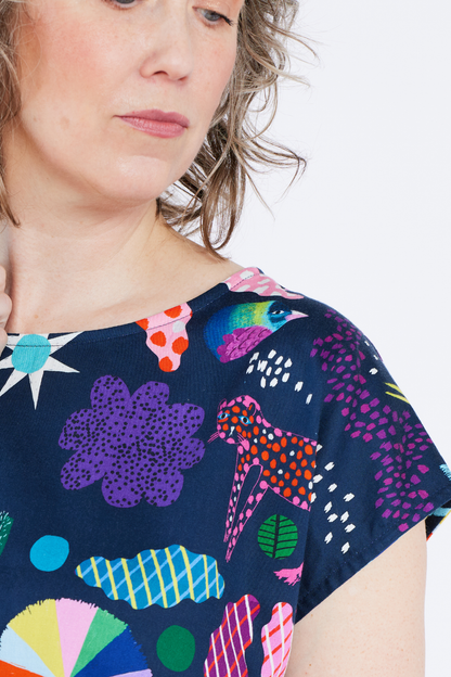 Person wearing a navy blue dress with colorful abstract patterns on a white background