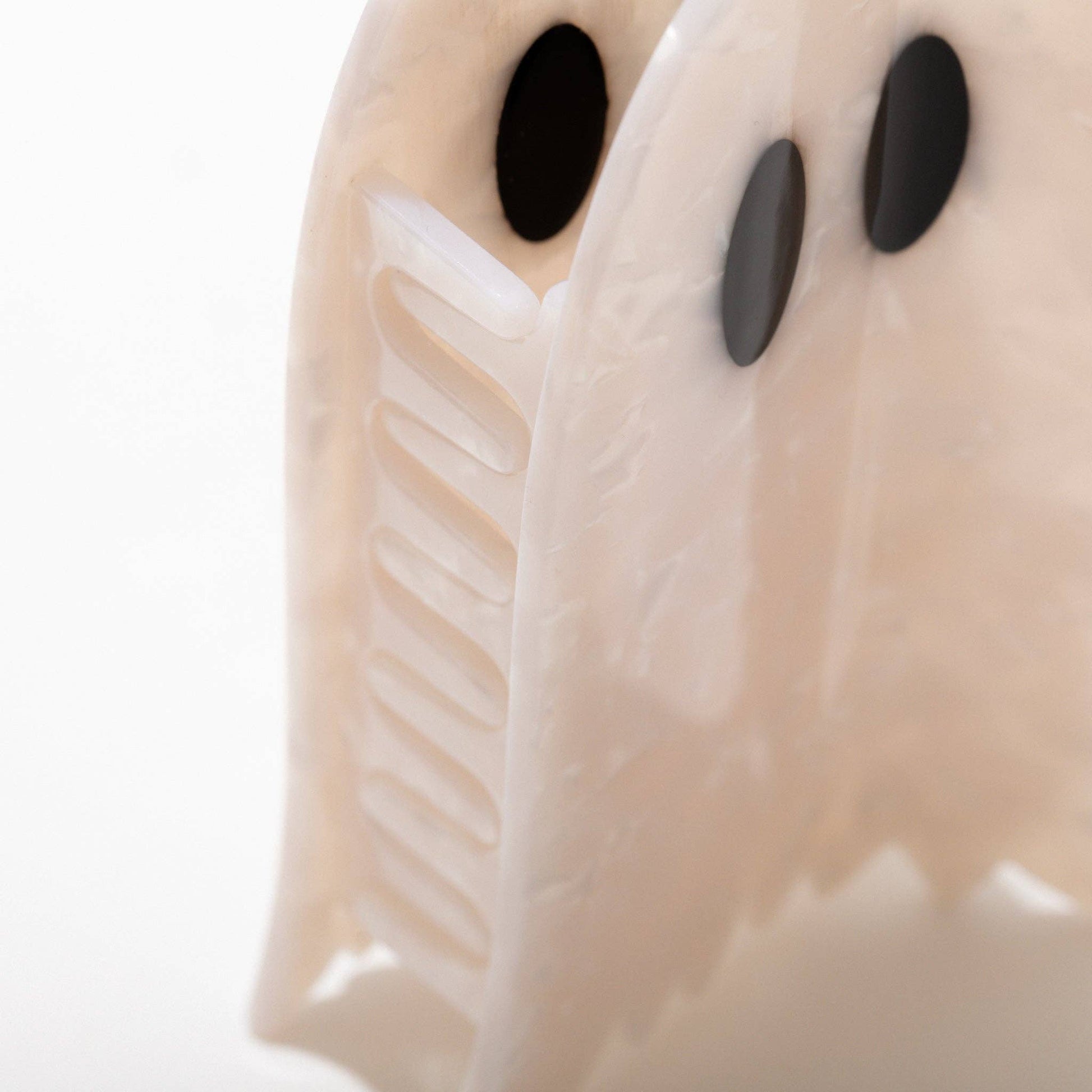 Close-up of a ghost-shaped hair clip with black eyes on a white background