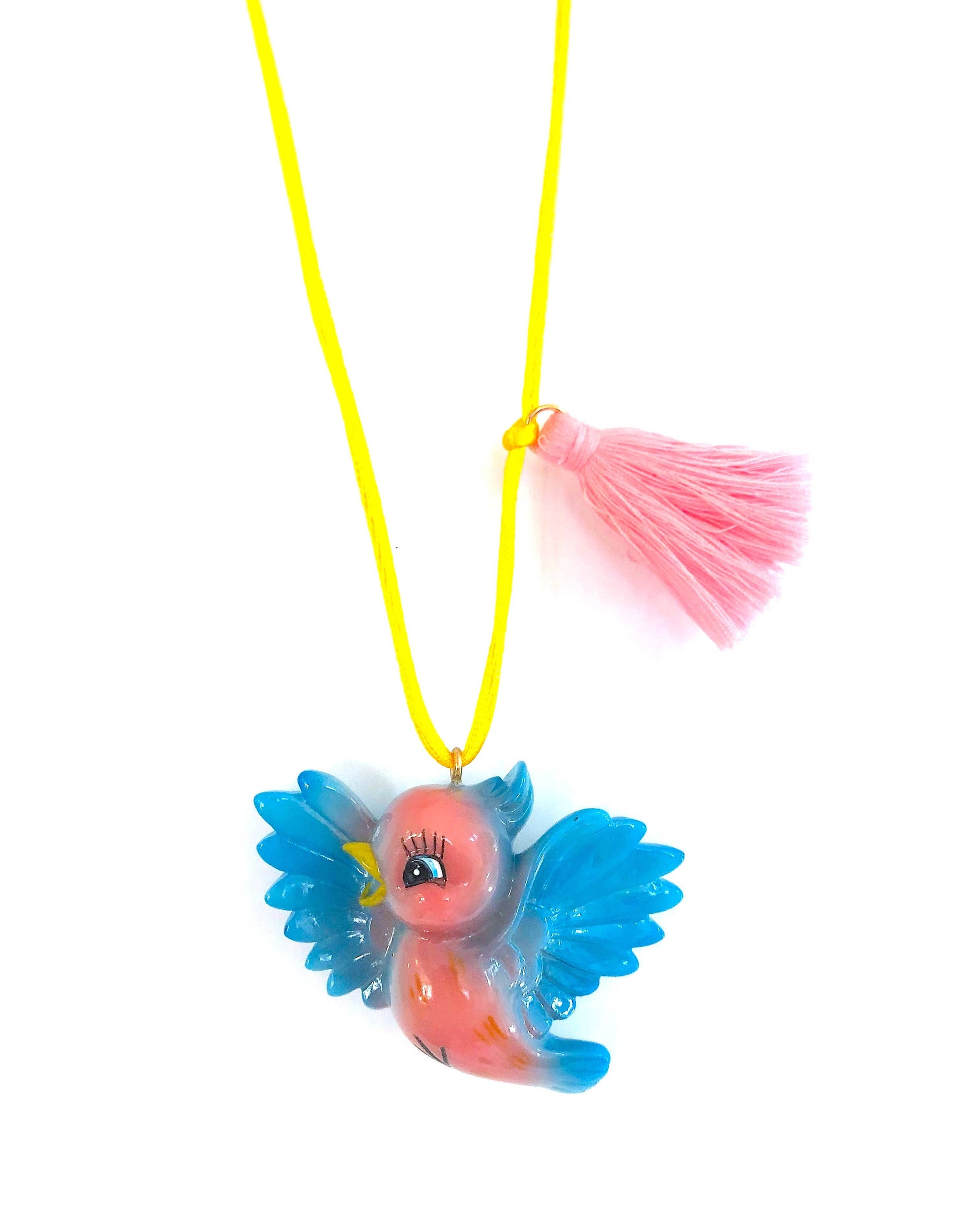 Neon pink and blue bird-shaped pendant on a yellow cord with a pink tassel against a white background