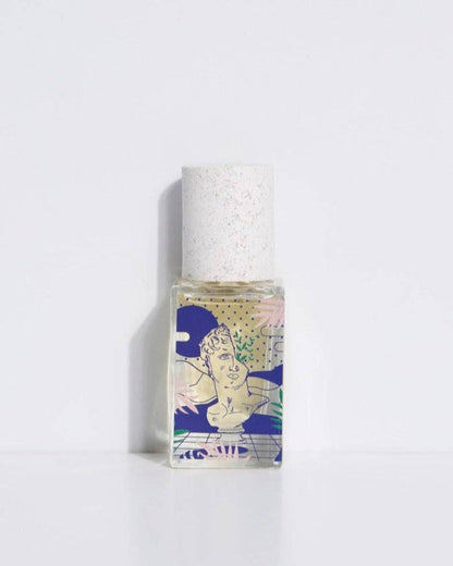 A bottle of 'Eau de parfum - Hasard Bazar' with a white cap and a label featuring a stylized, colorful illustration.
