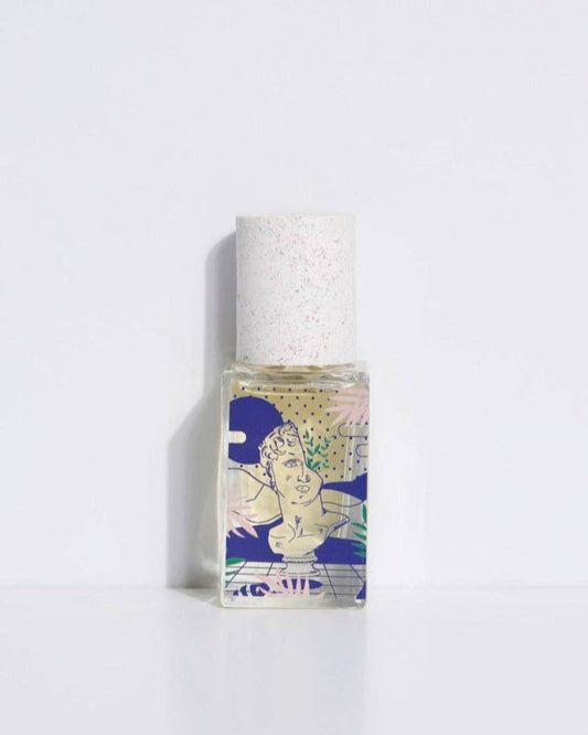 A bottle of 'Eau de parfum - Hasard Bazar' with a white cap and a label featuring a stylized, colorful illustration.
