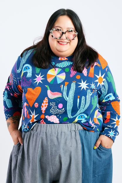 Person wearing a sustainable plus size colorful patterned shirt with a plain background