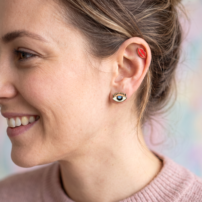 person wearing Mismatch stud earrings with one eye and one set of lips. 