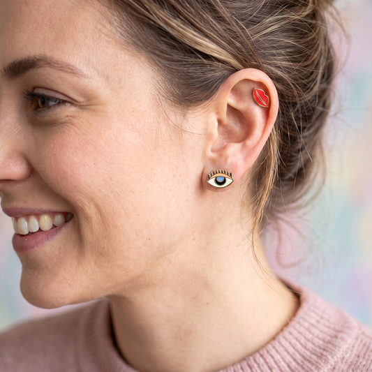 person wearing Mismatch stud earrings with one eye and one set of lips. 