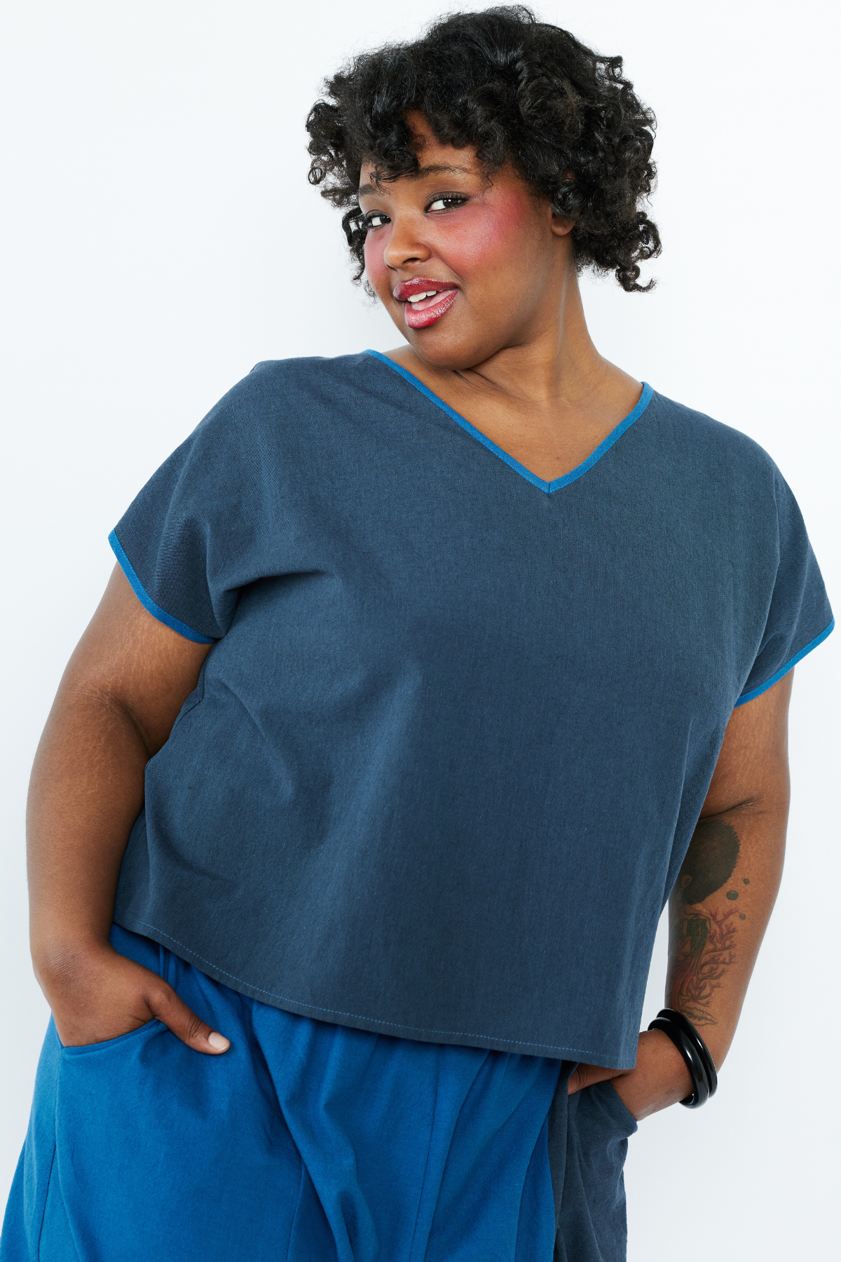 Woman wearing a blue top and pants on a white background