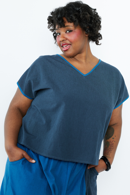 Woman wearing a blue top and pants on a white background
