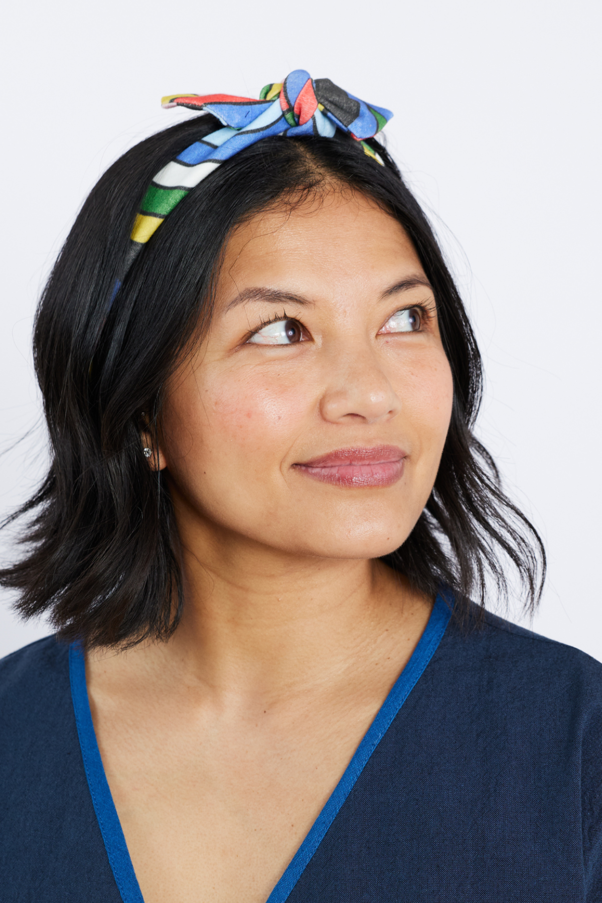 Woman wearing a colorful headband against a white background