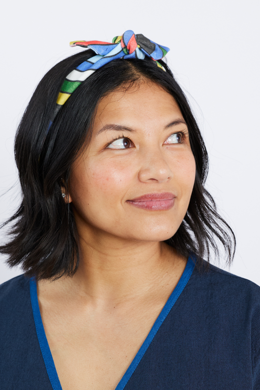 Woman wearing a colorful headband against a white background