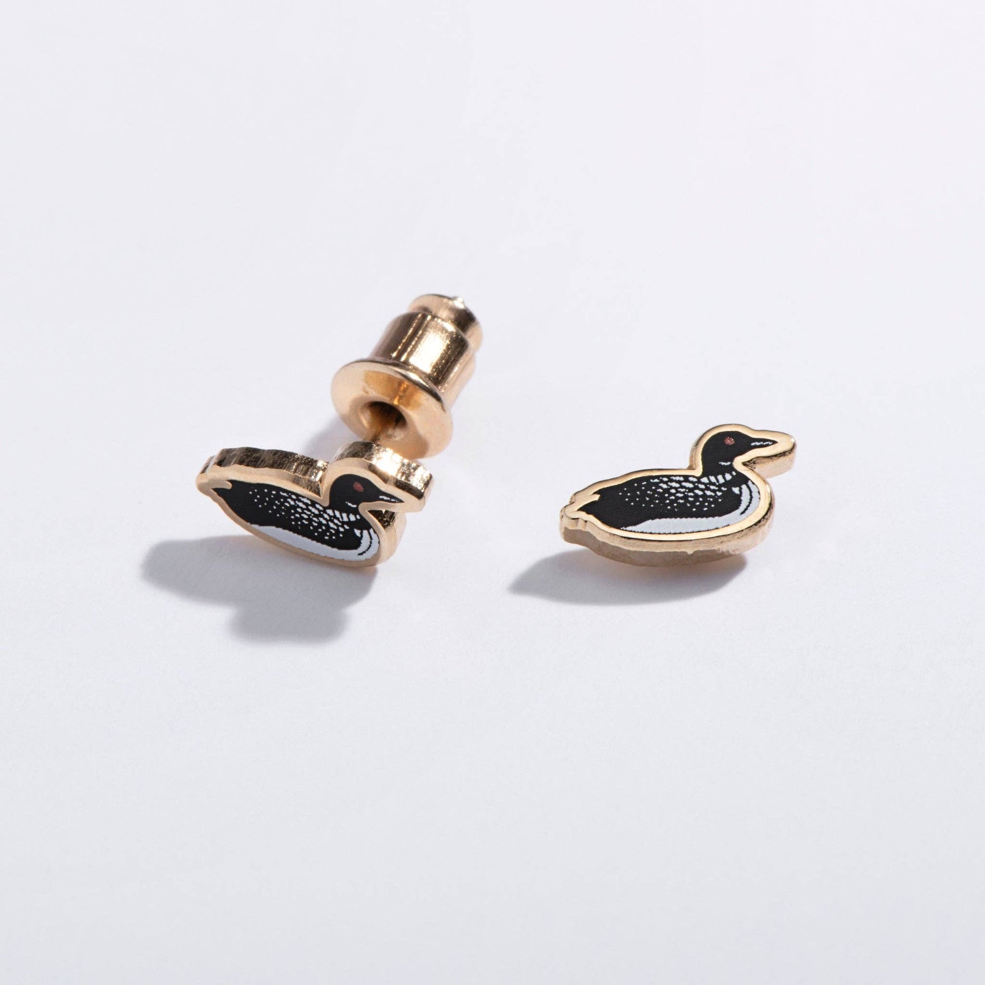 Pair of gold and black loon-shaped earrings on a white background