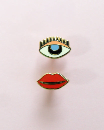 Mismatch stud earrings with one eye and one set of lips. sterling silver posts on a light pink background