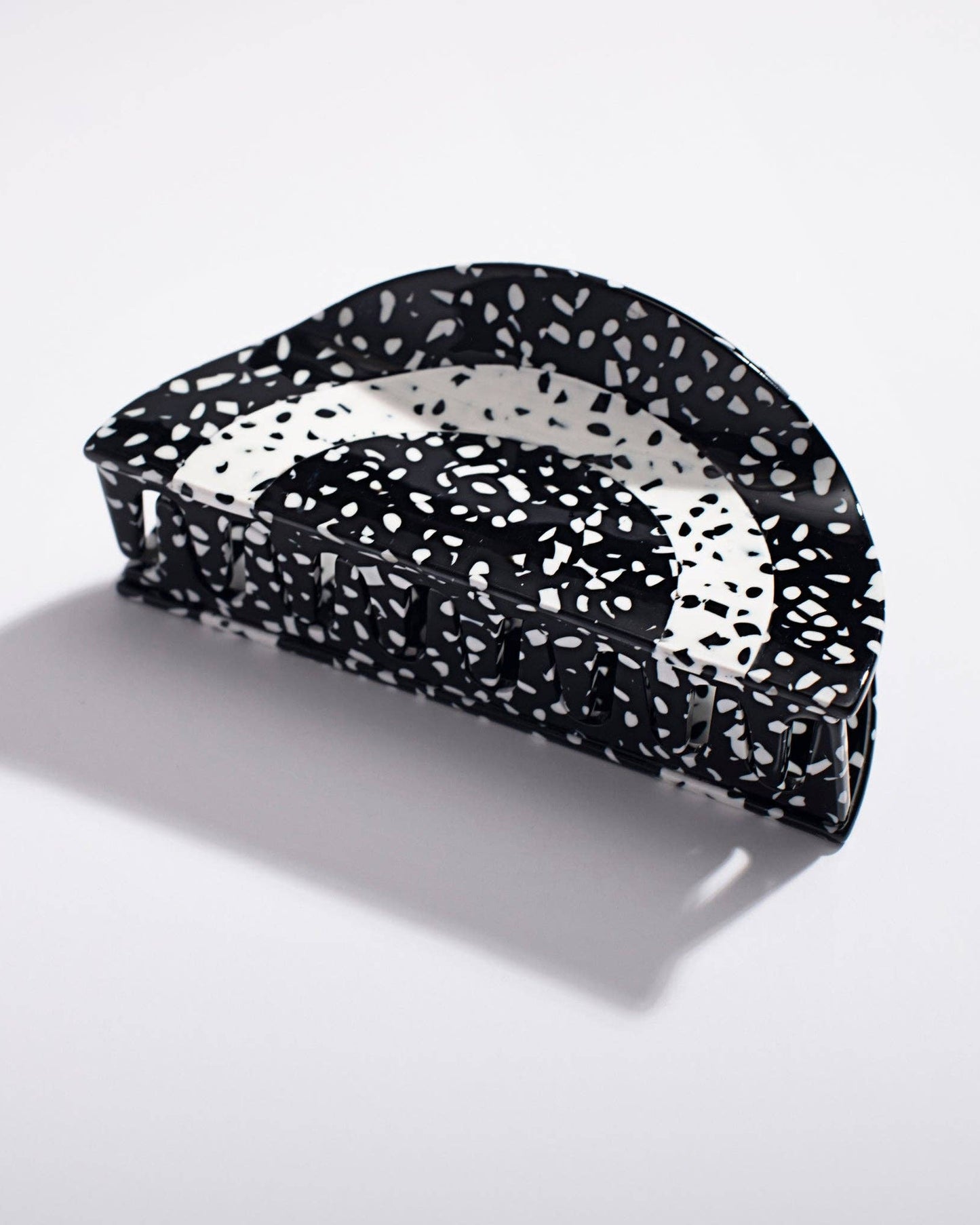 Black and white speckled hair clip on a light gray background
