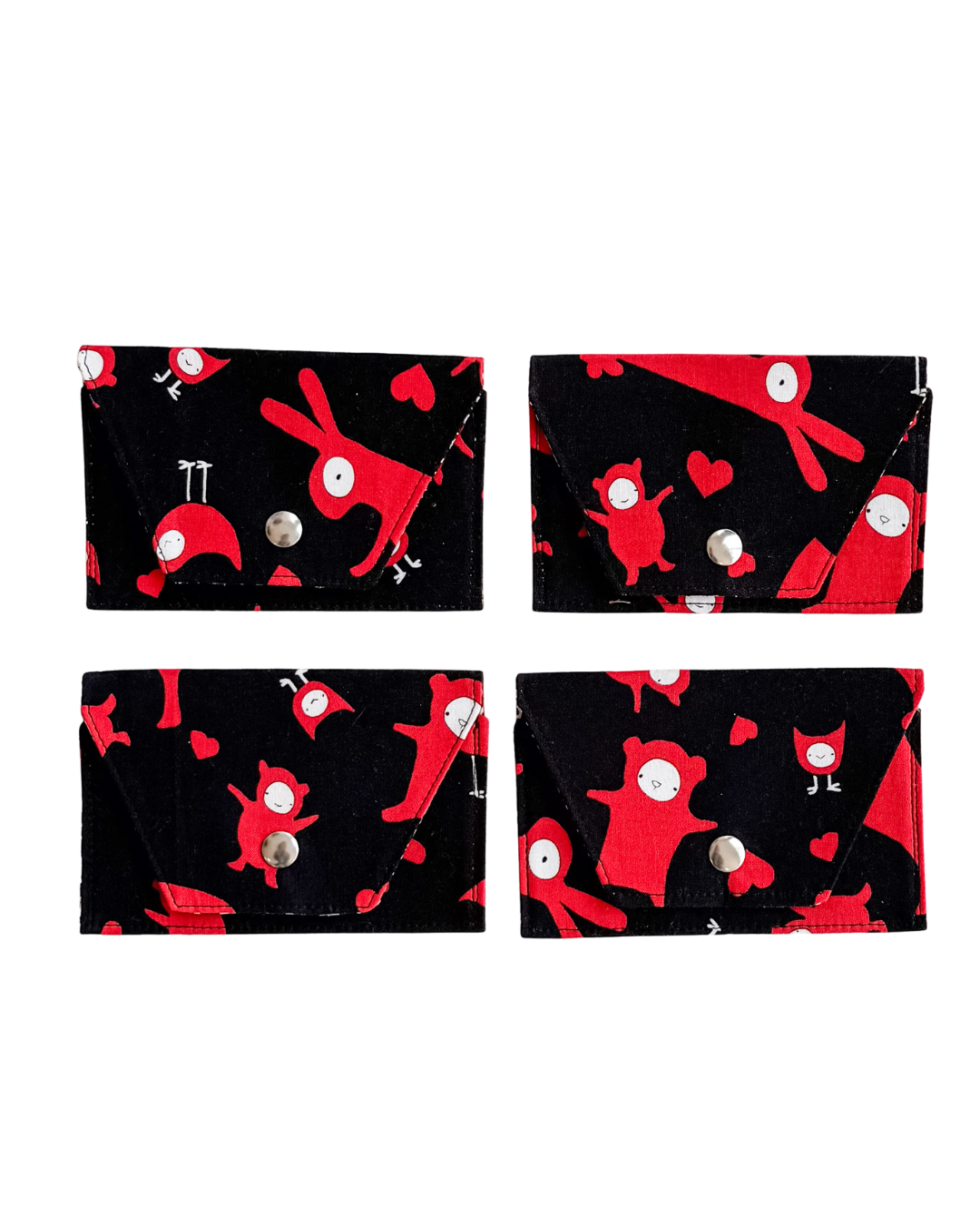 Four black mini wallet pouches with red and white cartoon character patterns on a white background