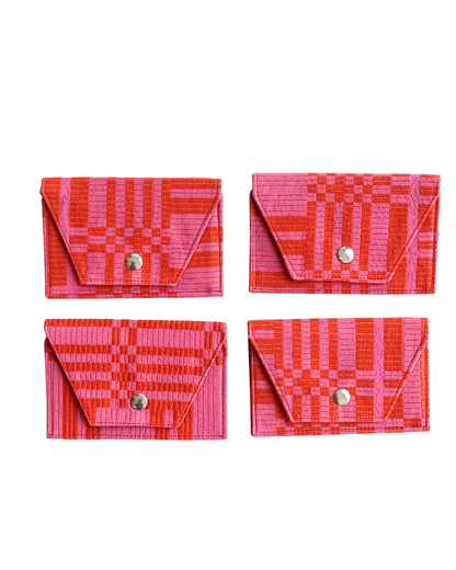 Four red and pink patterned card holders on a white background