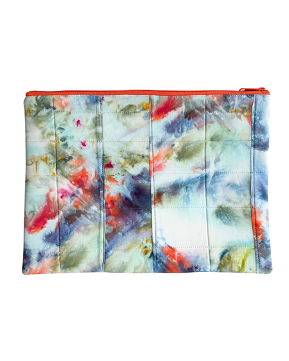 Multicolored tie-dye laptop sleeve with a red zipper on a white background