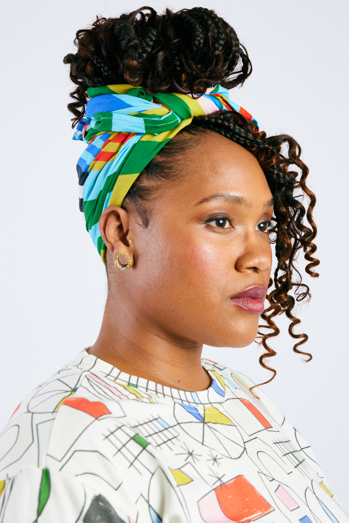 Woman wearing a colorful headscarf with a white background