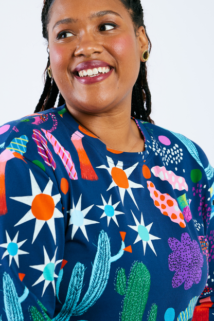 Woman wearing a colorful patterned shirt with a white background