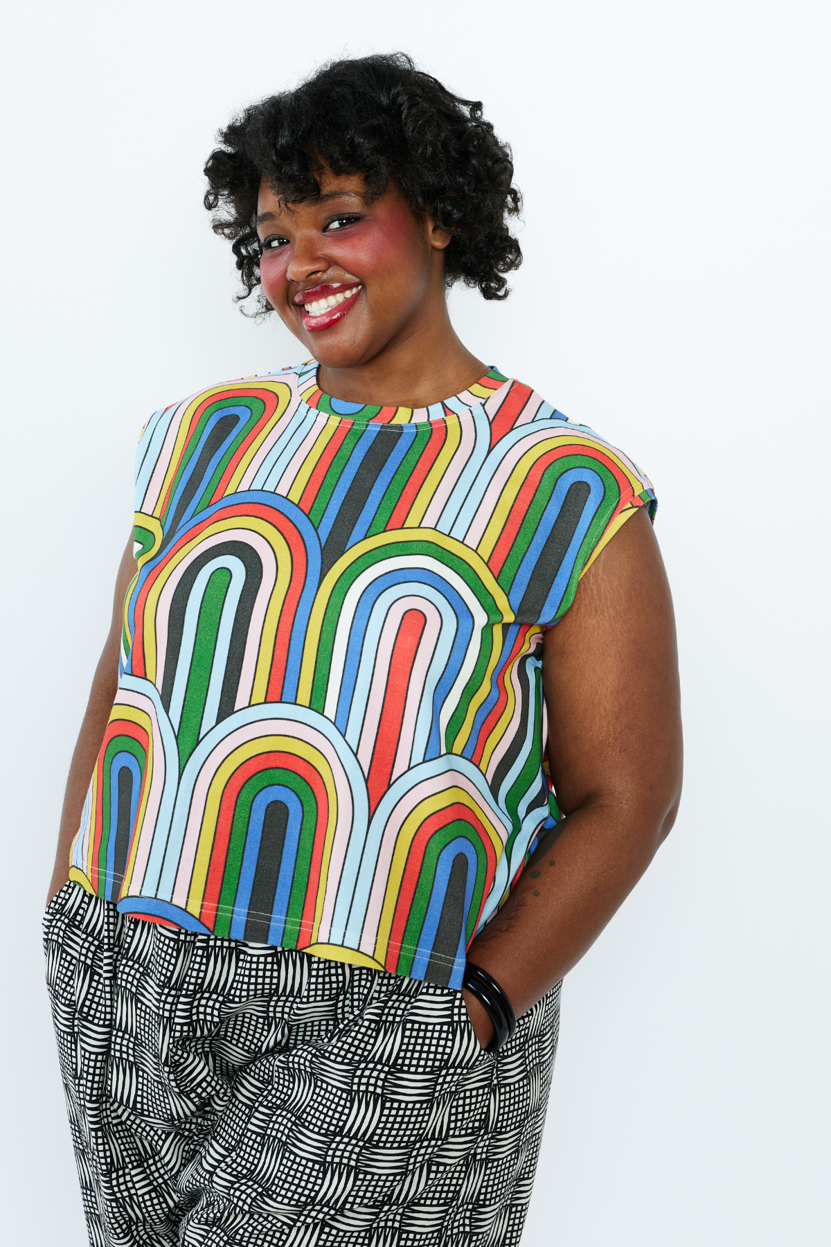 Person wearing a colorful patterned top with a plain background