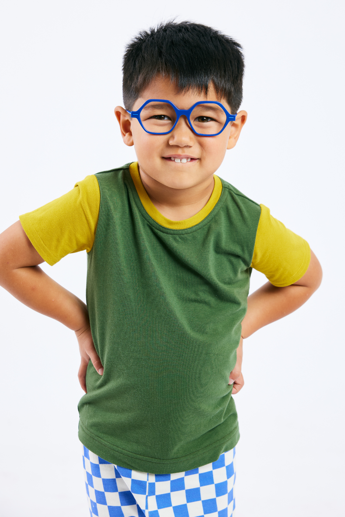 Child wearing sustainable green and yellow t-shirt, organic blue & white leggings,  and blue glasses from Eye Spy Optical