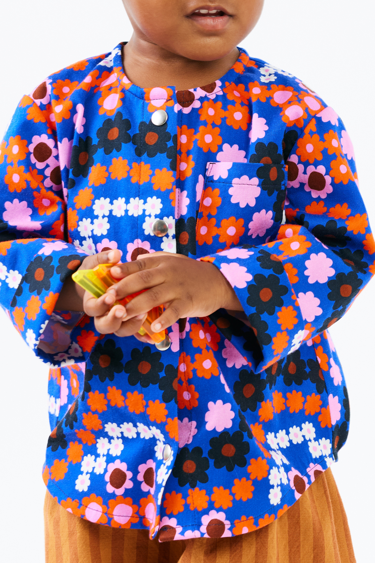Child wearing a colorful floral shirt on a white background