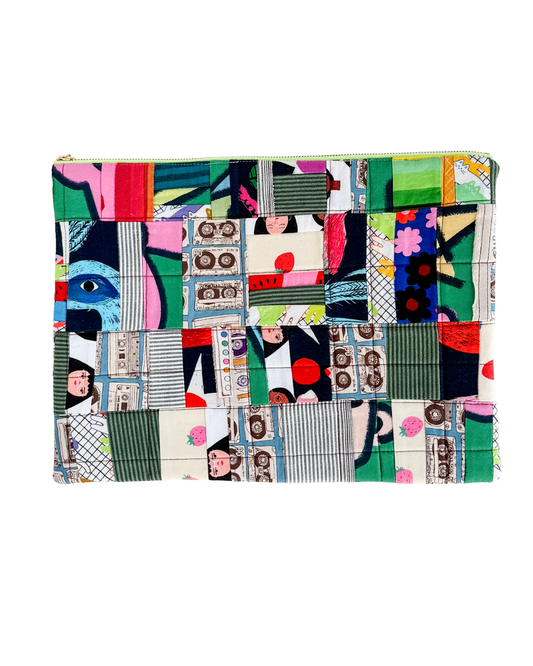 Colorful patchwork laptop sleeve with abstract patterns on a white background