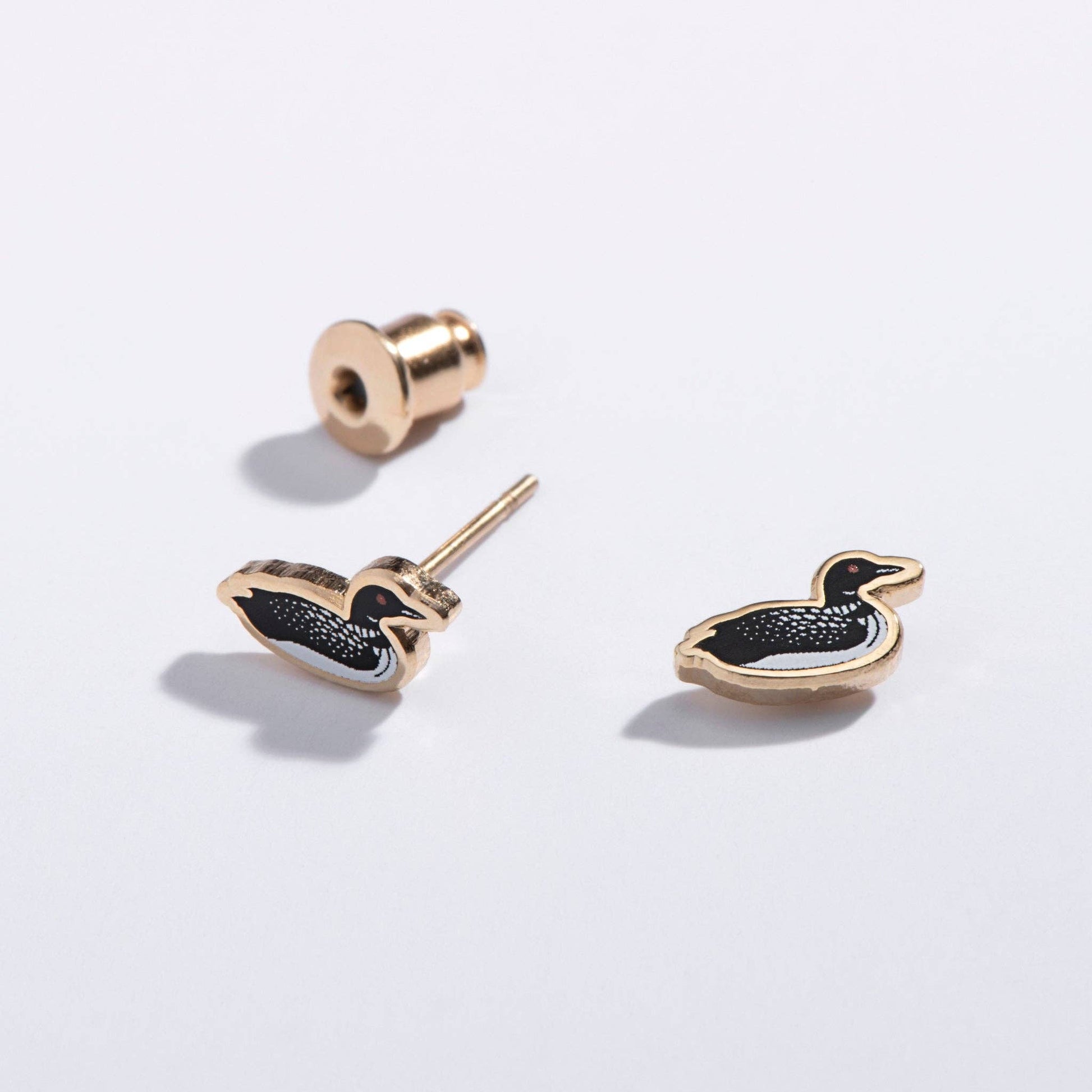 Pair of loon-shaped earrings on a light gray background