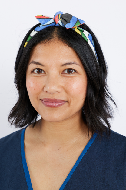 Woman wearing a colorful headband with a plain background