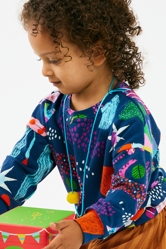 Child wearing a soft and colorful shirt with abstract patterns on a white background